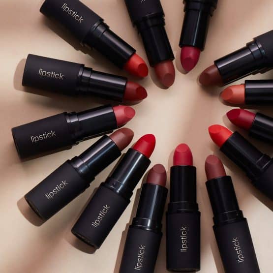 Cosmetics product photography of lipstick constellation in reds and nudes on quality photo studio matte black casings